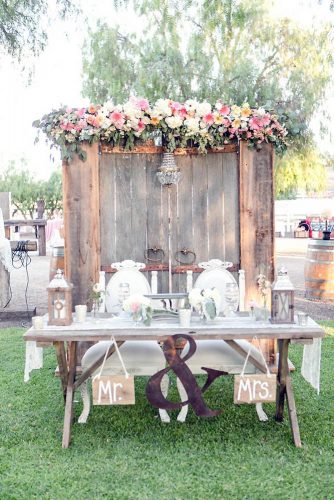 old door wedding decoration wedding table of the bride and groom on the background of the door decorated with a chandelier and flowers leah marie photography