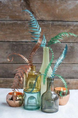 non floral wedding centerpieces in the glass bottles of paper feathers tutorial from lia griffith