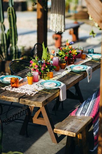wedding taco bar a wooden table with a bench is decorated with napkins with bright flowers and dishes benjamin hewitt photography