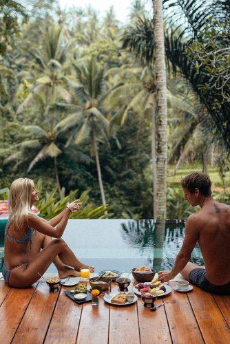 best honeymoon spots bali vacation couple have lunch near pool