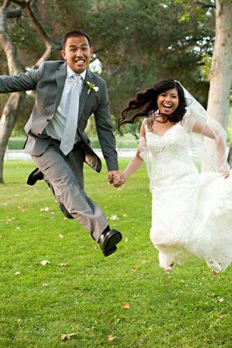 awkward wedding photos funny bride and groom jump at the grass bill blakey photography