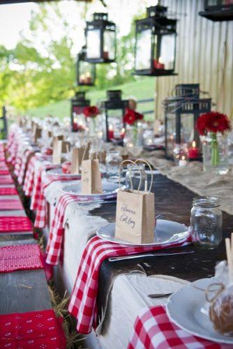 rustic barbecue bbq wedding table decorated with lanterns with red candles flowers and napkins in white plates small paper bags martini wedding & event photography