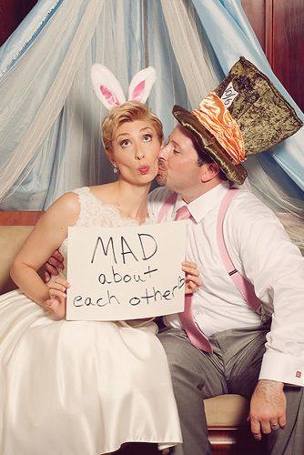 themed wedding photos alice in wonderland bride and groom with sign mad about each other andi and zoe photographers