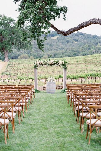 wine barrels at the end of the wedding pass a flower arch and a wine barrel rachel solomon photography