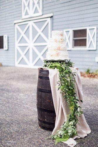 wine barrels decorated with a cloth and greenery on which stands a tall white cake hunter ryan photo