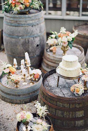 wine barrels decorations with candles flowers and a small white cake peaches and mint photography