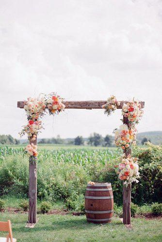 wine barrels simple wooden arch decorated with flowers and a wine barrel wooden weddings via instagram