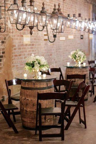 wine barrels small tables with white flowers in a golden vase surrounded by candles greer gattuso photography