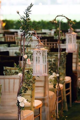 lantern wedding centerpiece aisle decorated with white lanterns suspended on wooden branches with flowers muse books via instagram