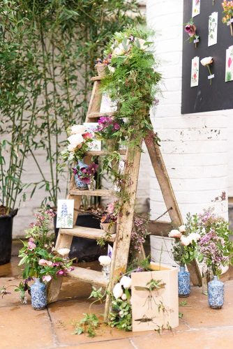 rustic backyard wedding decoration wooden ladder decoration with moss and flowers in blue vases anushé low
