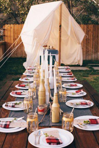 rustic barbecue bbq wedding a long wooden table with gold bottles of candlesticks white plates and red checkered napkins steve steinhardt