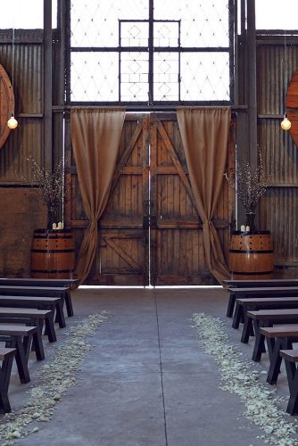 wine barrels decorate the ceremony in the barn lost in love via instagram