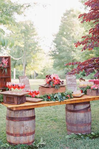 wine barrels on the basis of wine barrels table with cocktails and decor of flowers jodi kurt baier via instagram