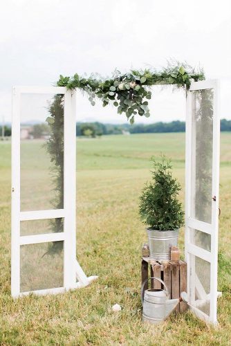 old door wedding decoration decorated with greenery and trees in a metal bucket in rustic style ally and bobby fine art photography