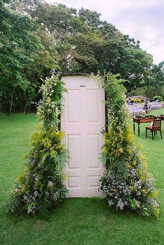 old door wedding decoration white door painted with bushy greens and flowers mark cantalejo photography