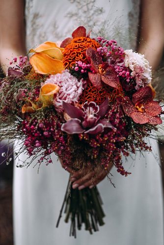 bridal bouquet with dark orchids and orange flowers lorena erre photography