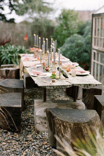 rustic backyard wedding decoration rough wooden table with candles and hemps instead of chairs josh gruetzmacher photography