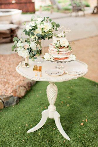 western wedding decoration dessert table with nacked cake greenery and white flowers koman photography