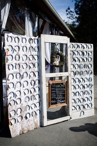 western wedding decoration escort stand on white doors with metal horseshoes j + a photography