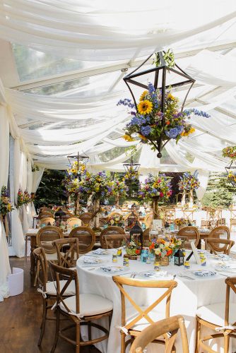 western wedding decoration reception uder white tent with bright flowers elevate photography