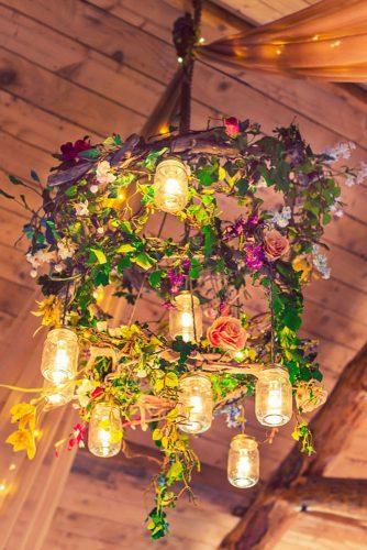 hippie wedding chandelier with candles in jars decorated with greens and flowers daisy b photography