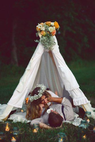 hippie wedding groom and bride chillind in white teepee decorated with flowers megan w photography