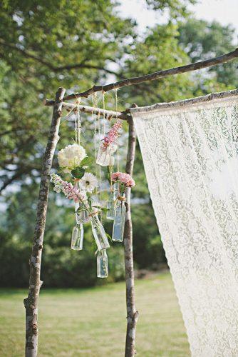 hippie wedding rustic boho arch decoreted with lace glass bottles and flowers