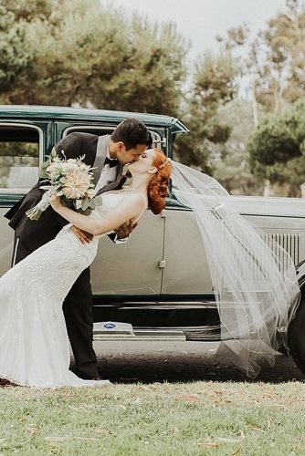 vintage wedding theme newlyweds kissing near old car