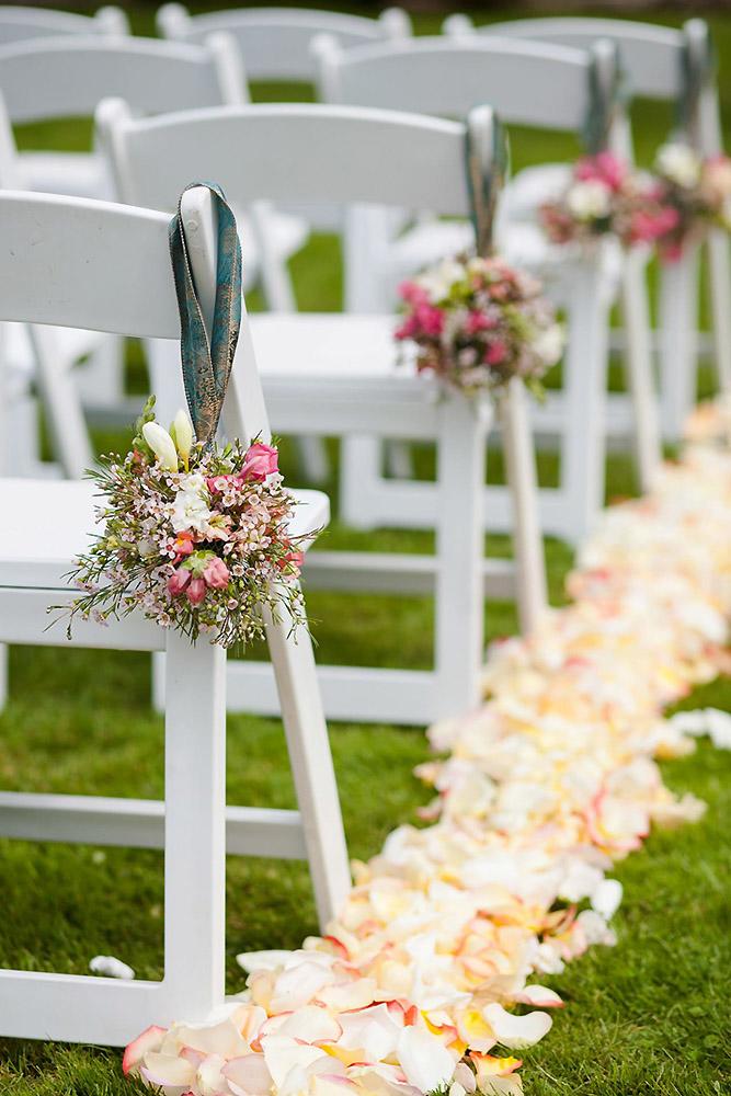 wedding aisle decoration ideas on white chairs wildflowers pink petals en vied events