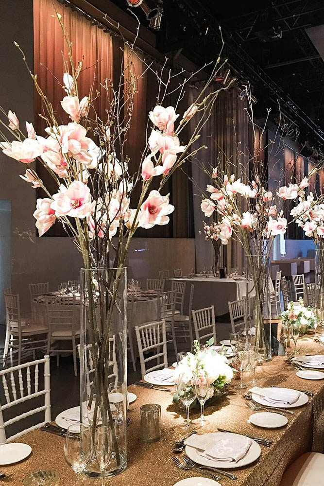 tall wedding centerpieces in a clear even vase wooden branches with pink flowers delight floral design via instagram