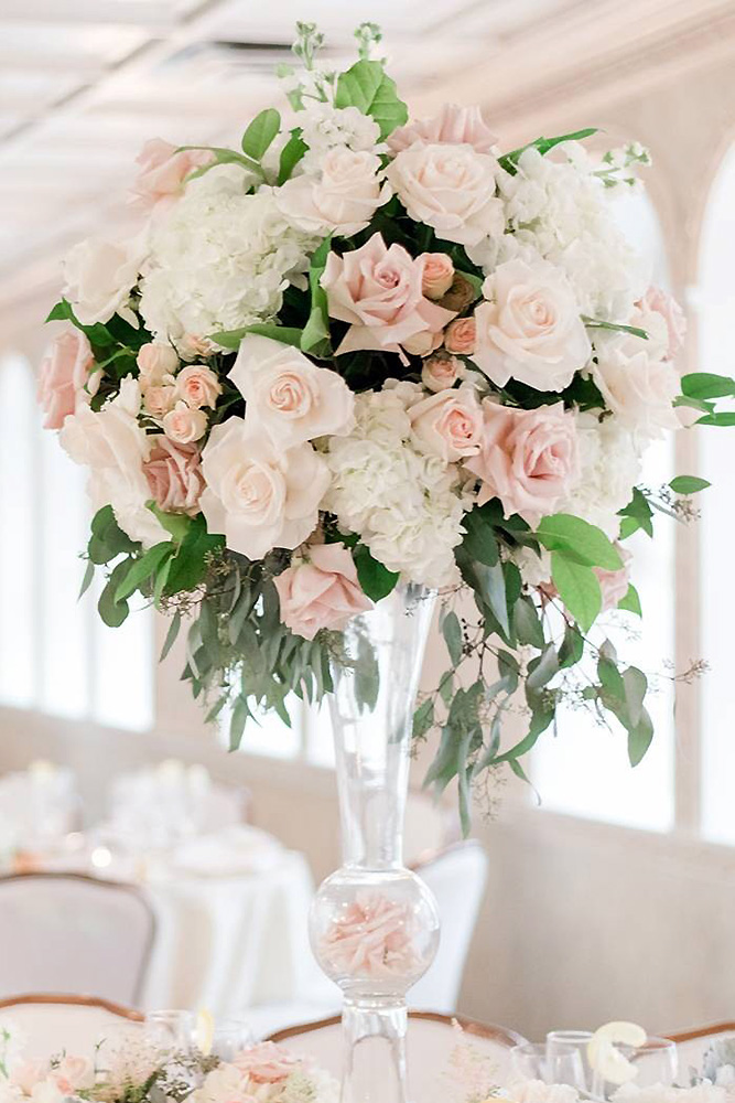 tall wedding centerpieces in a transparent glass vase white flowers and ruddy roses with greens amy rizzuto via instagram