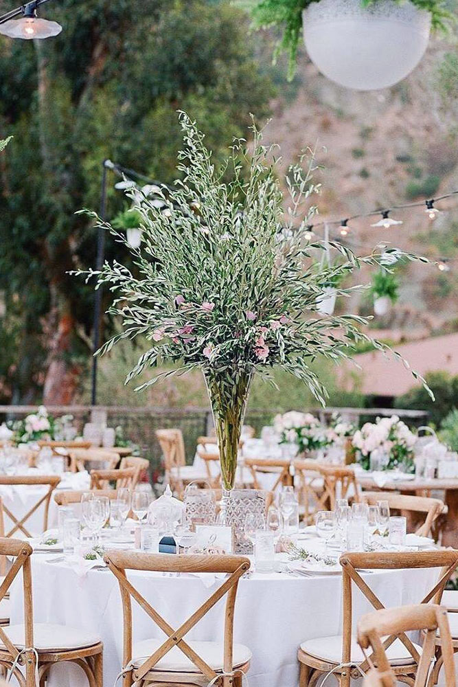 tall wedding centerpieces on a table with vase greens and cory & gloria mccune via instagram