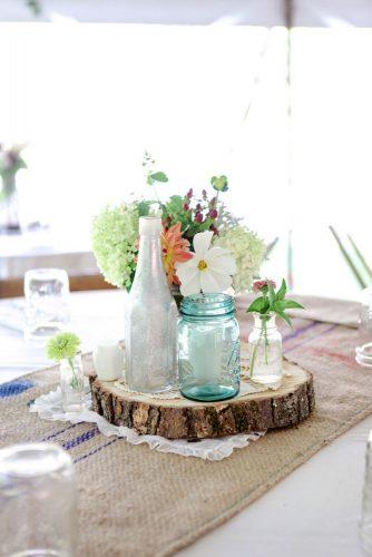 mason jars wedding centerpieces blue glass on wooden slice dan and melissa photography