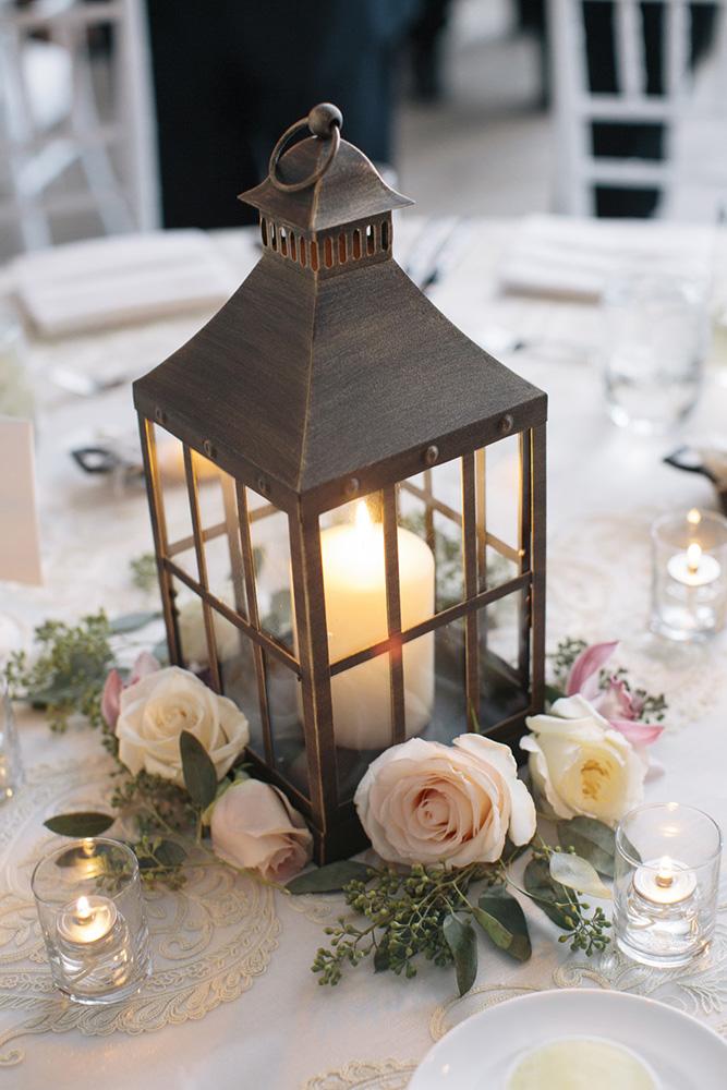 rustic wedding lanterns with a candle roses on wooden slice kate preftakes photography