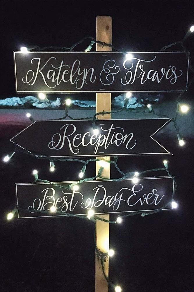 popular wedding signs direction on a black background in the evening in the lights megs truly via instagram