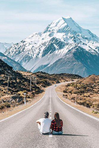 affordable honeymoon packages new zealand couple sitting at the road mountains
