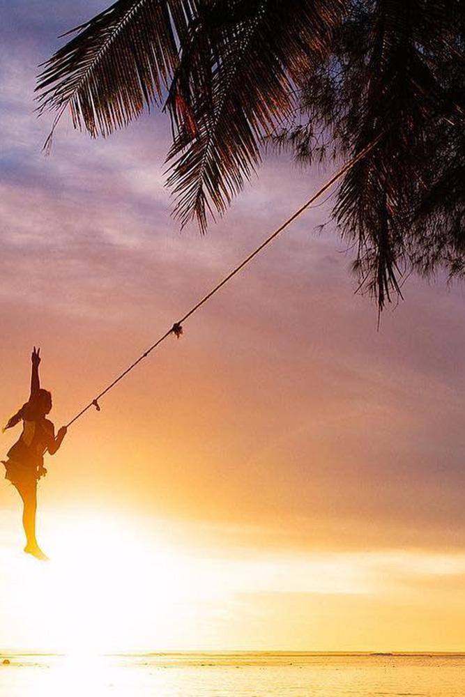 tropical honeymoon destinations cook islands a girl on the tarp in sunset sjanaelise via instagram