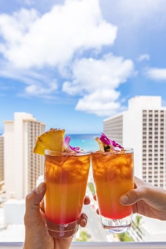 hawaii honeymoon clink glasses on the hotel balcony hyattplacewaikiki
