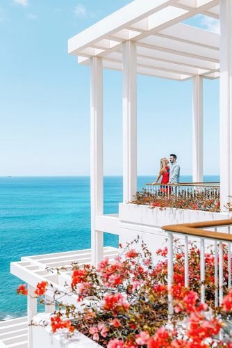 hawaii honeymoon couple on a white veranda decorated with red flowers lifeandmylens