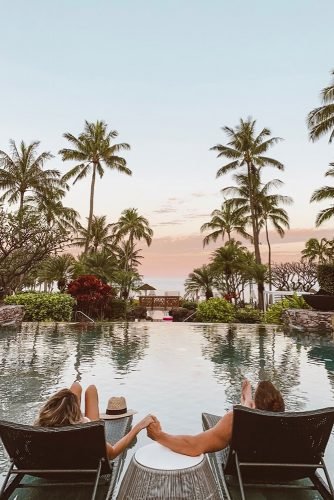 hawaii honeymoon couple on the loungers by the pool hellofashionblog