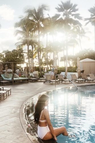 hawaii honeymoon girl at the pool among the high palm trees lizvaugin