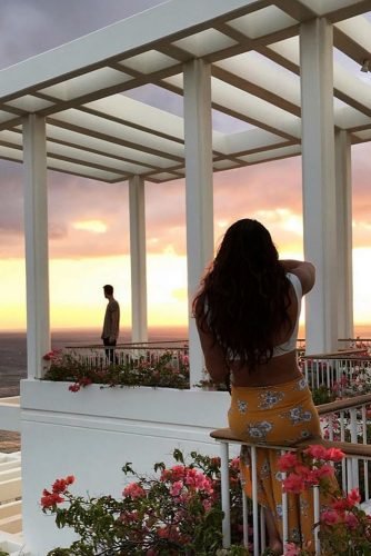 hawaii honeymoon girl takes a picture of a guy on the veranda in flowers chelseakauai