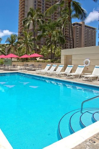 hawaii honeymoon swimming pool with sun loungers in the courtyard ramadaplazawaikiki