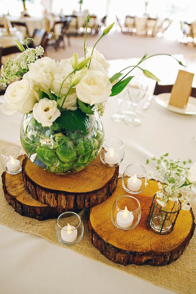 rustic wedding centerpieces white roses in a transparent vase on wooden slices rose street studio