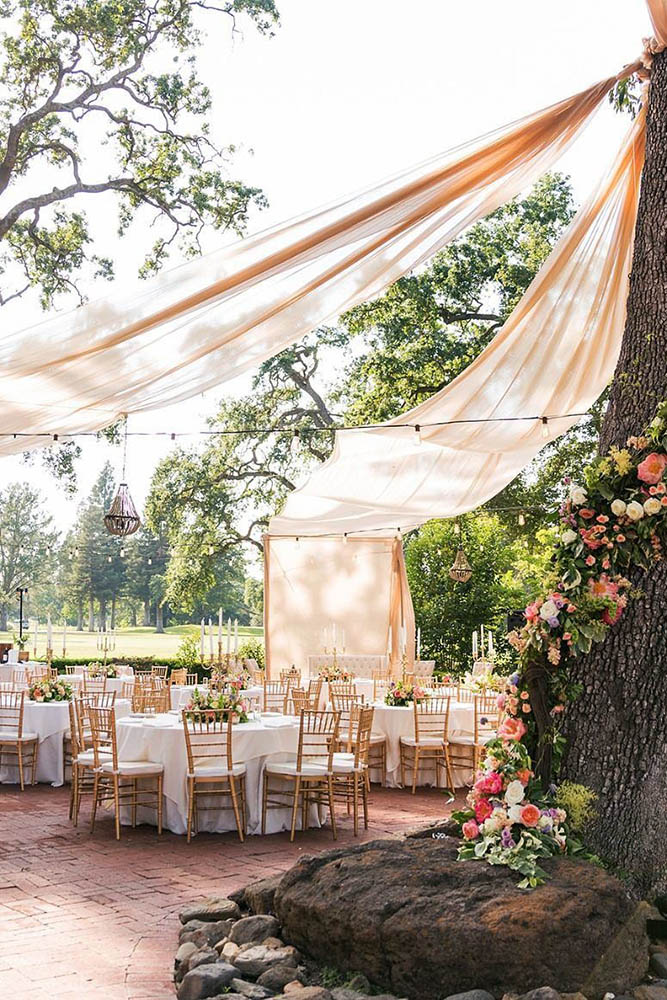 wedding tent light pink cloth tree decorated with flowers quintana events via instagram