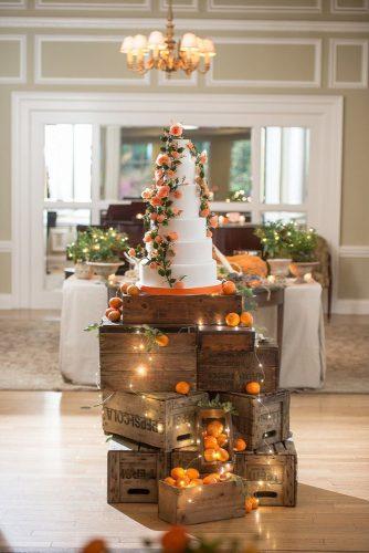 wooden crates wedding ideas dessert stand with oranges lighting garland and tall cake Krista Fox Photography