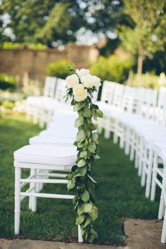 budget rustic wedding greens and white roses décor on a chair in the aisle