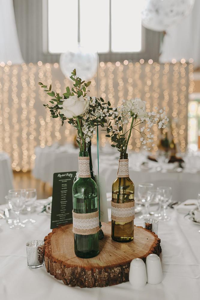 country wedding flowers in grass bottles with burlap and lace kelsie low photography