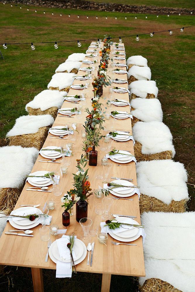 country wedding long table decorated with flowers and hay bale seatings eyeswoon via instagram