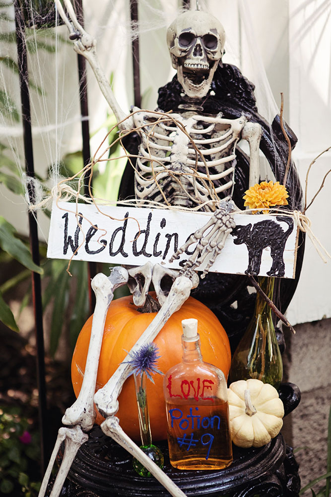 halloween wedding ideas on a pumpkin sits a skeleton in a spiderweb with an inscription wedding april smith & co photography